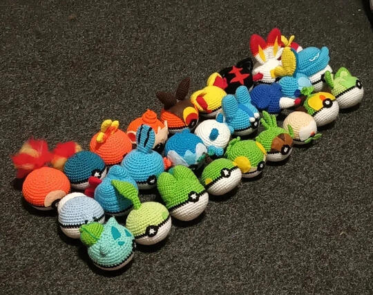 A set of crocheted pokeballs made to like look the starter pokemon of each generation.