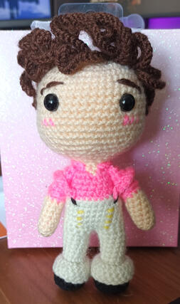 A crocheted plushie of Harry Styles.