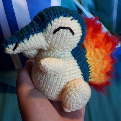 A crocheted plushie of the pokemon Cyndaquil.