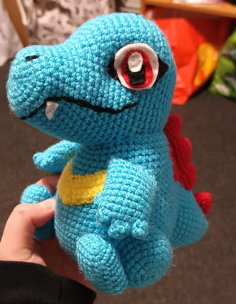 A crocheted plush of the pokemon Totodile