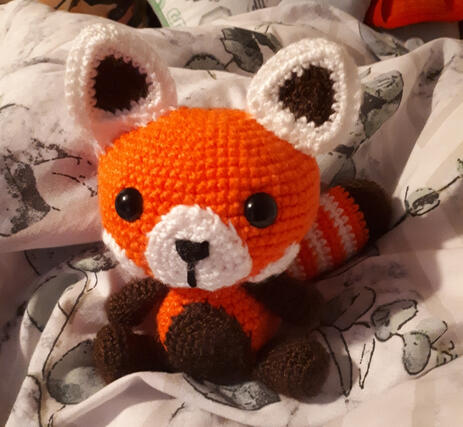 A crocheted plushie of a red panda