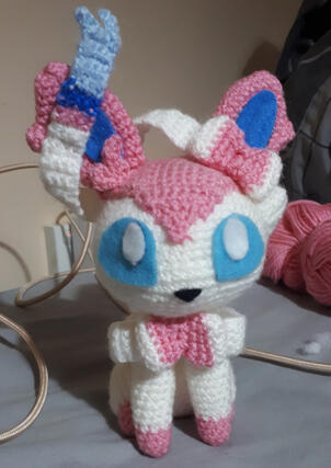 A crocheted plushie of the pokemon Sylveon)