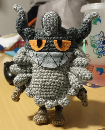 A crocheted plushie of the pokemon Perrserker.